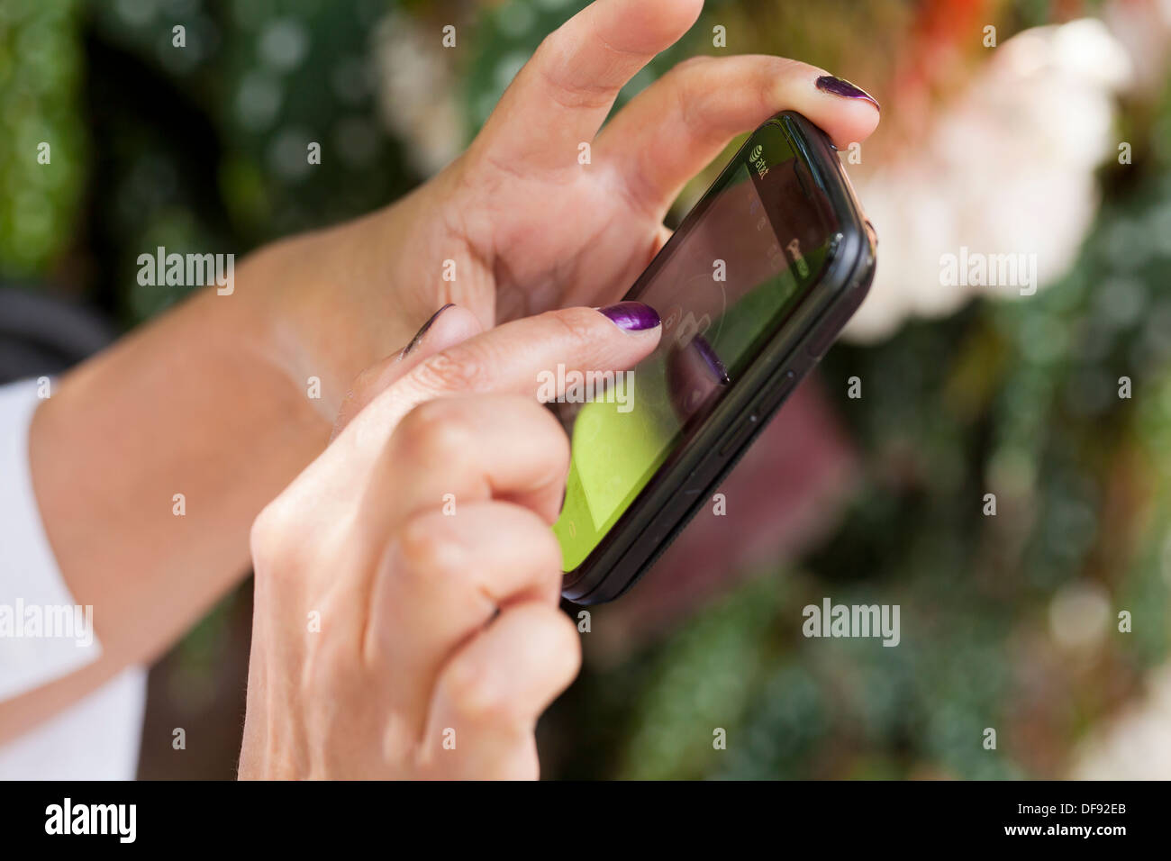Primer plano de las manos de la mujer utilizando teléfonos inteligentes. Foto de stock
