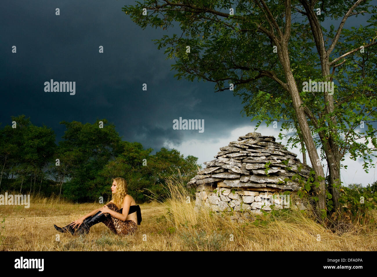 Mujer joven delante de Istria' 'kazun cabaña de piedra justo antes de la Tormenta, Croacia, Europa Foto de stock