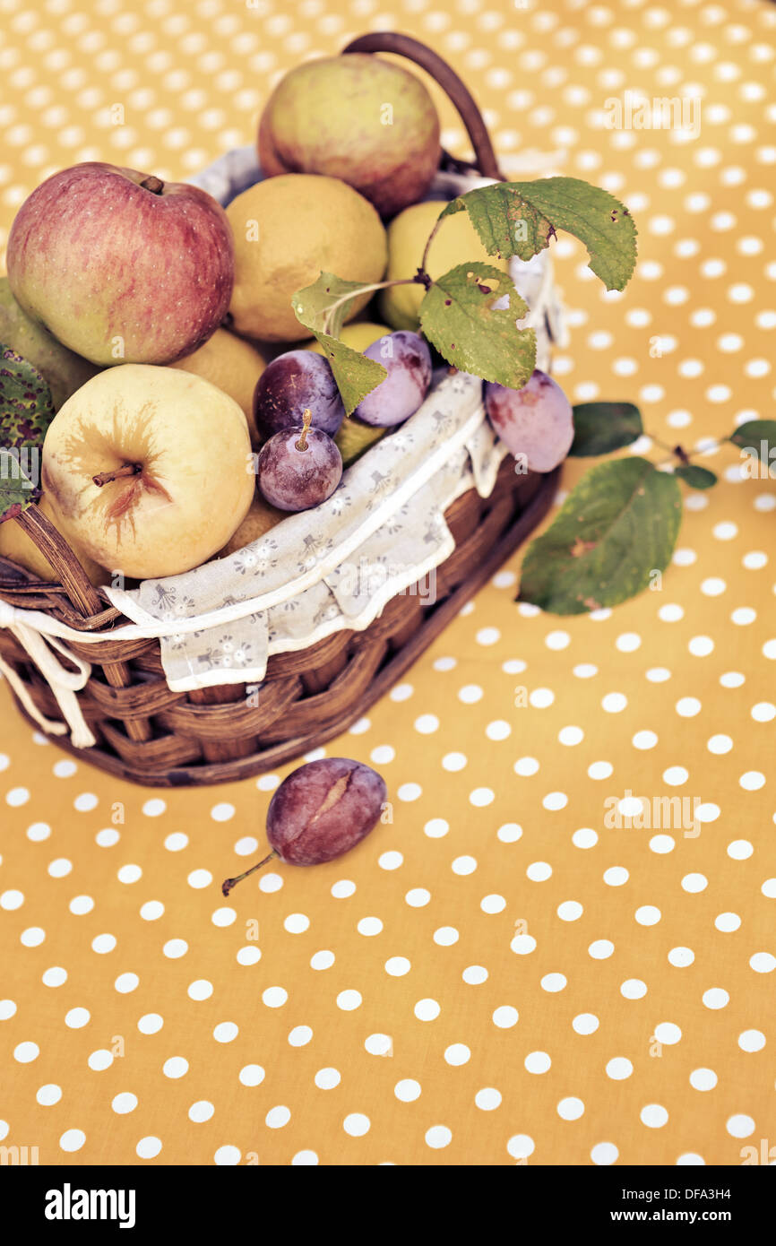 Poco cesta de frutas con bio frutas en la mesa Foto de stock