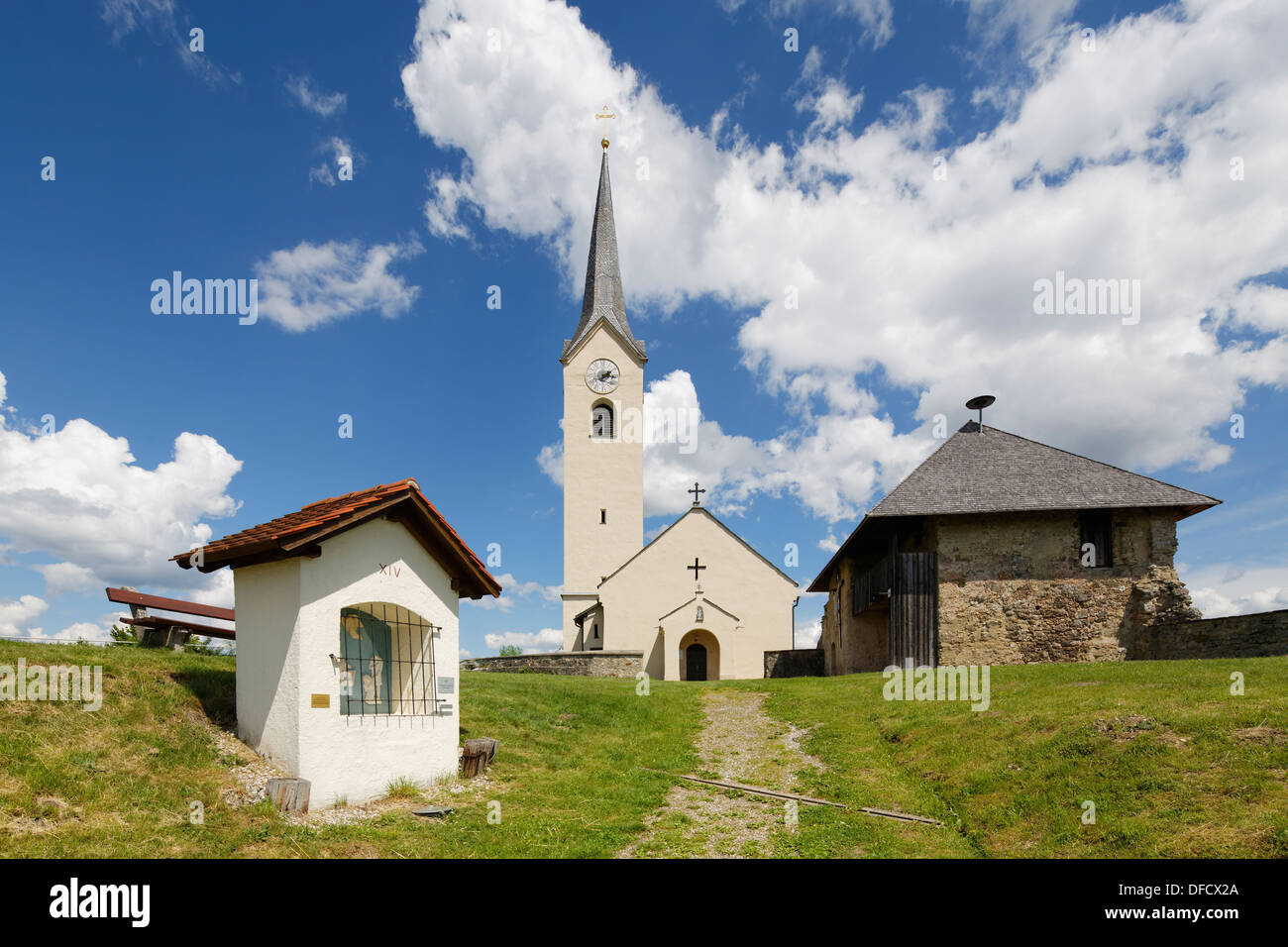 Austria, Carintia, estación XIV moderna de El Calvario y la iglesia parroquial de piedra jauntal Foto de stock