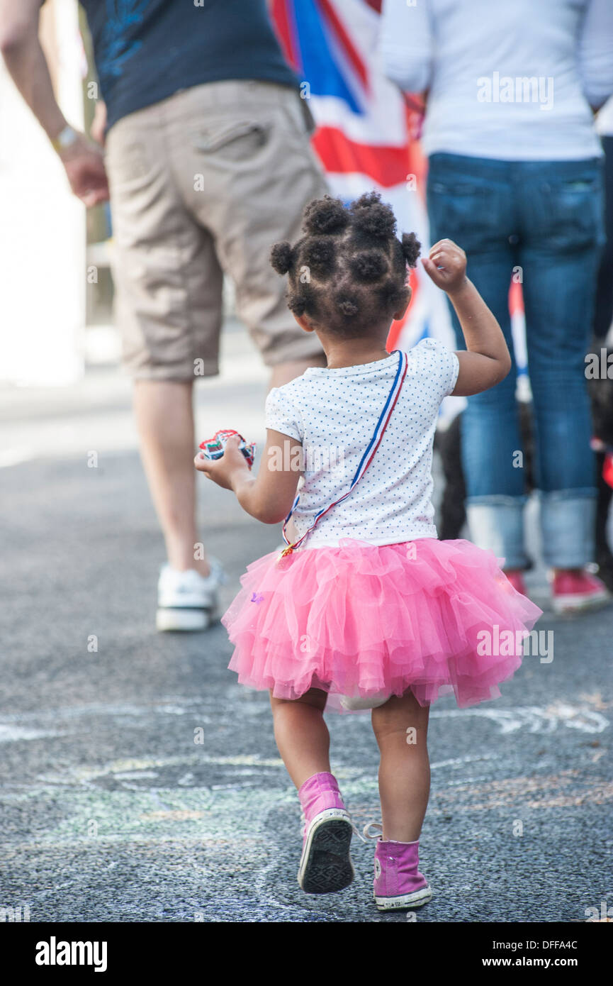 Una niña en un rosa con botas paseos a lo largo de Fotografía stock - Alamy