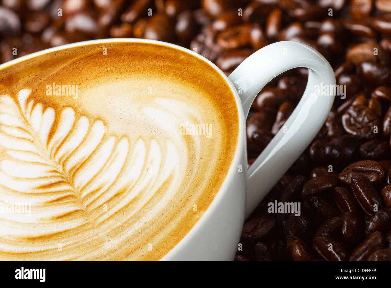 Latte art, café en granos de café antecedentes Foto de stock