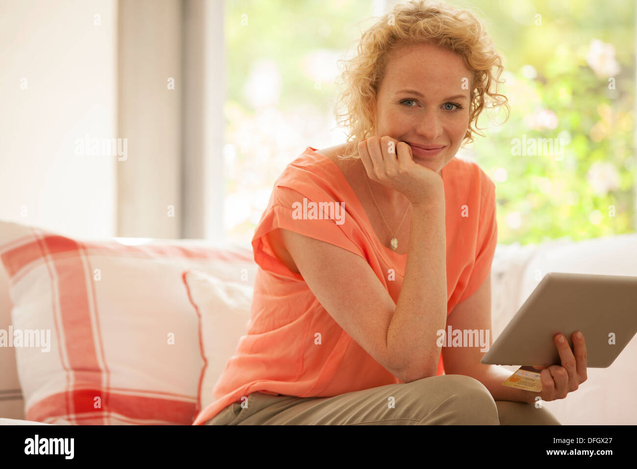 Retrato de mujer utilizando tablet digital en el sofá Foto de stock
