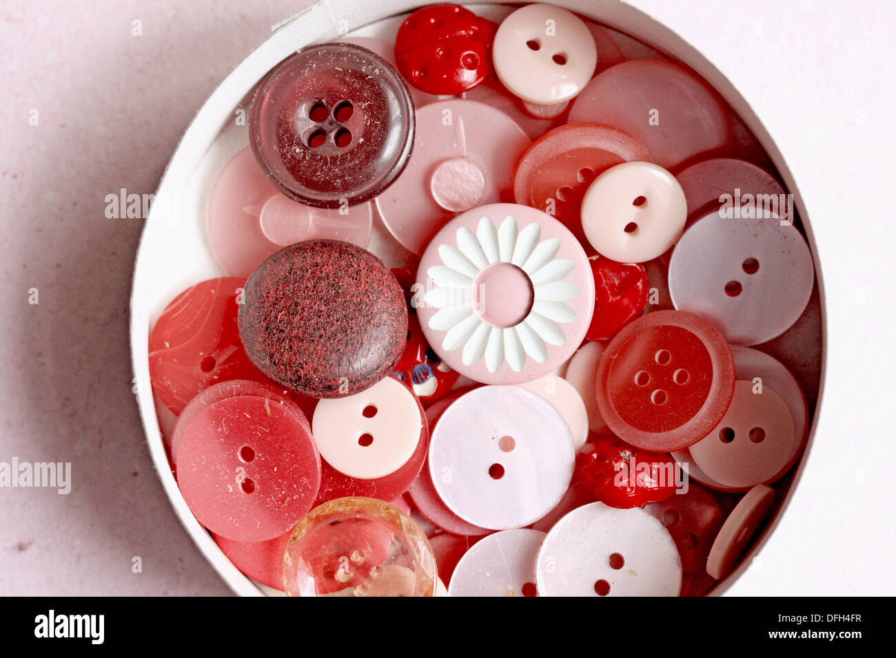 Caja de rosas y botones rojos mezclados o surtido de tamaños y materiales  de madera, conchas, botones de plástico y vidrio en el cuadro Fotografía de  stock - Alamy