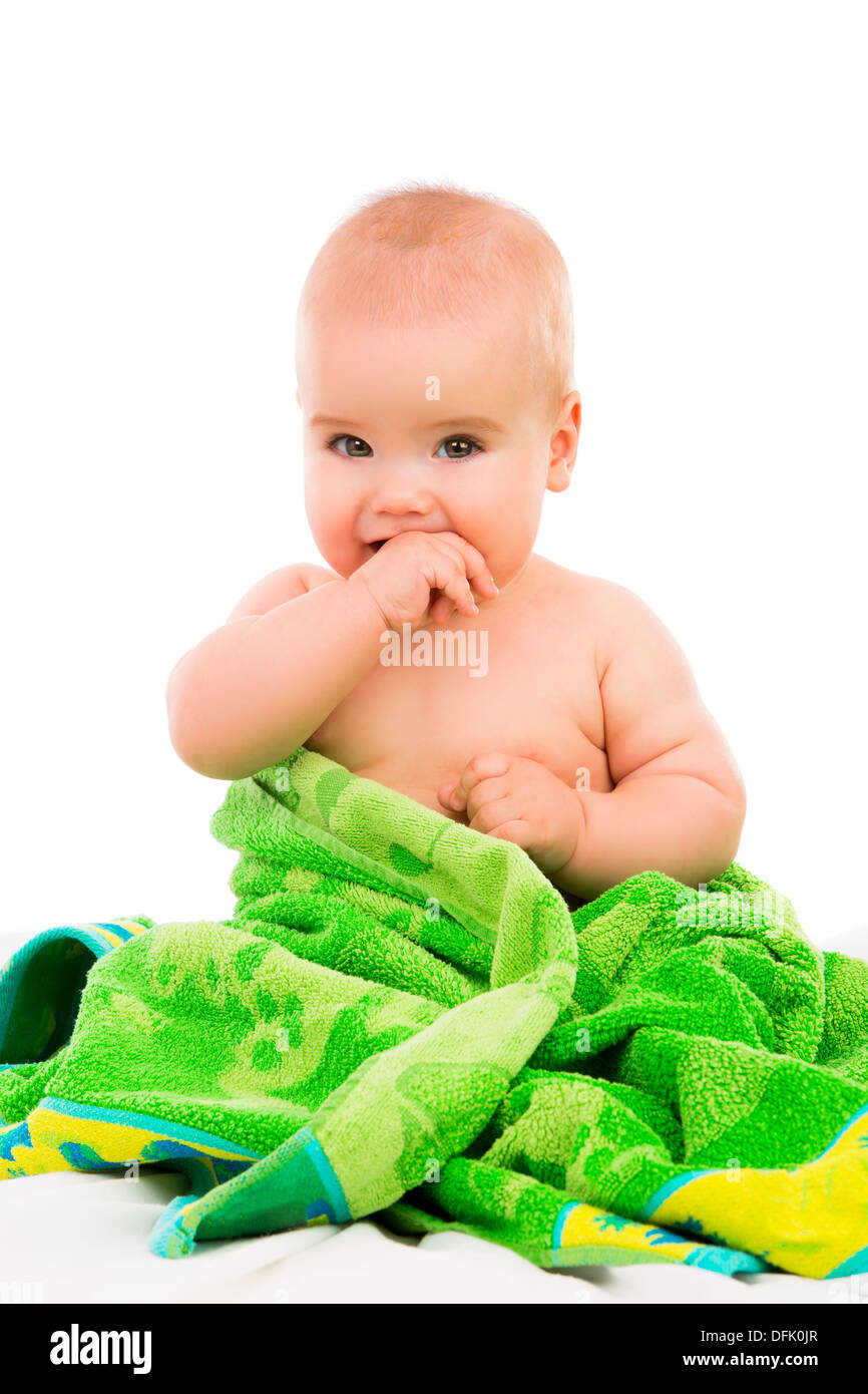 Poco feliz Bebé en toalla verde sobre fondo blanco. Foto de stock