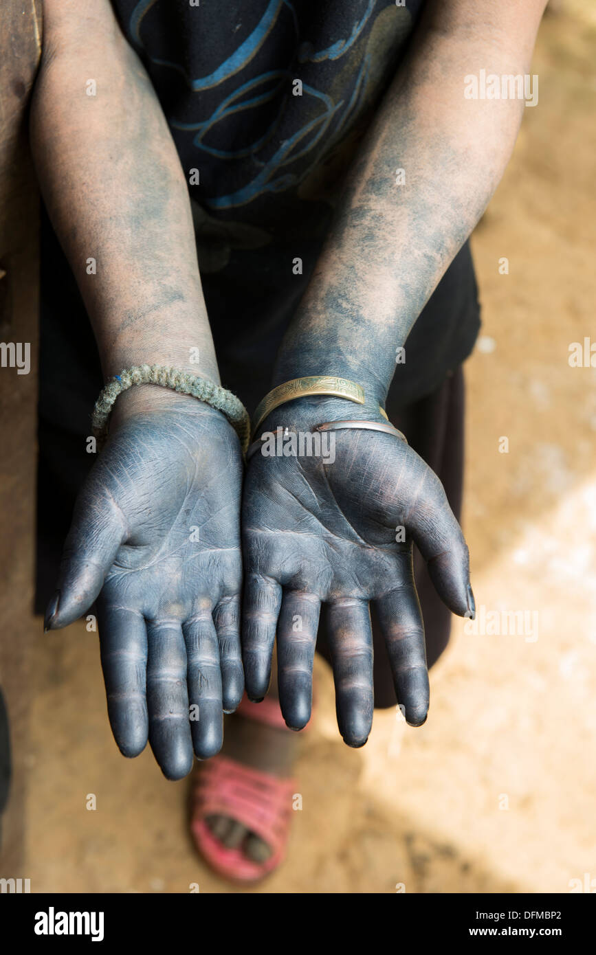 Mujer mostrando la mano, color azul profundo de tintura de índigo hizo el trabajo cotidiano de la tela tradicional de la minoría Hmong negro. Foto de stock