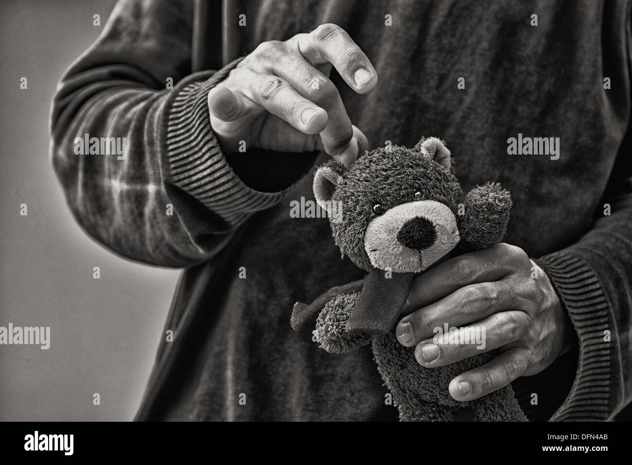 El hombre matar a Teddy bear, el concepto de abuso infantil Foto de stock