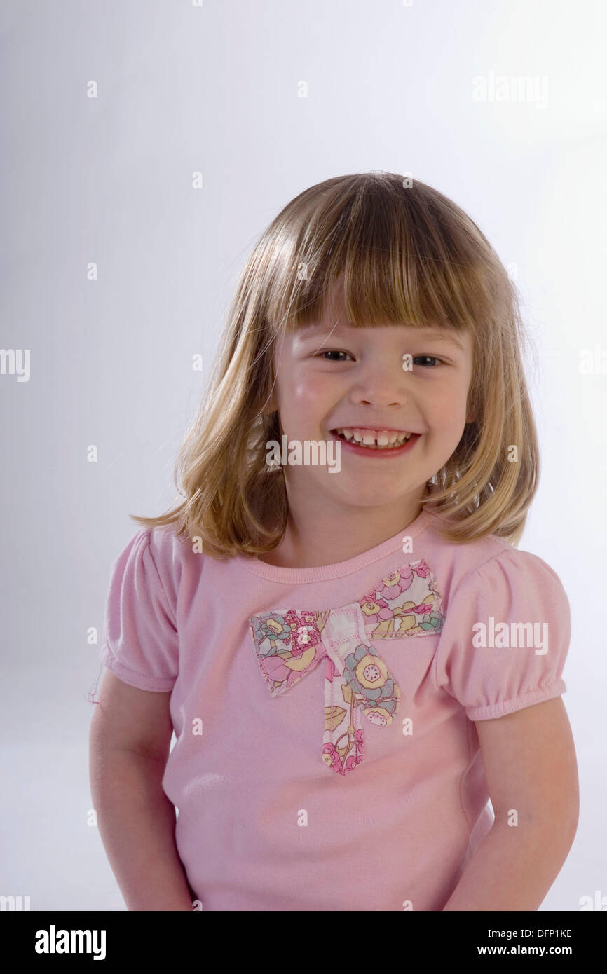 Niña de 3 años de edad mirando a la cámara, tres cuartos de longitud,  sonriendo y riendo Fotografía de stock - Alamy