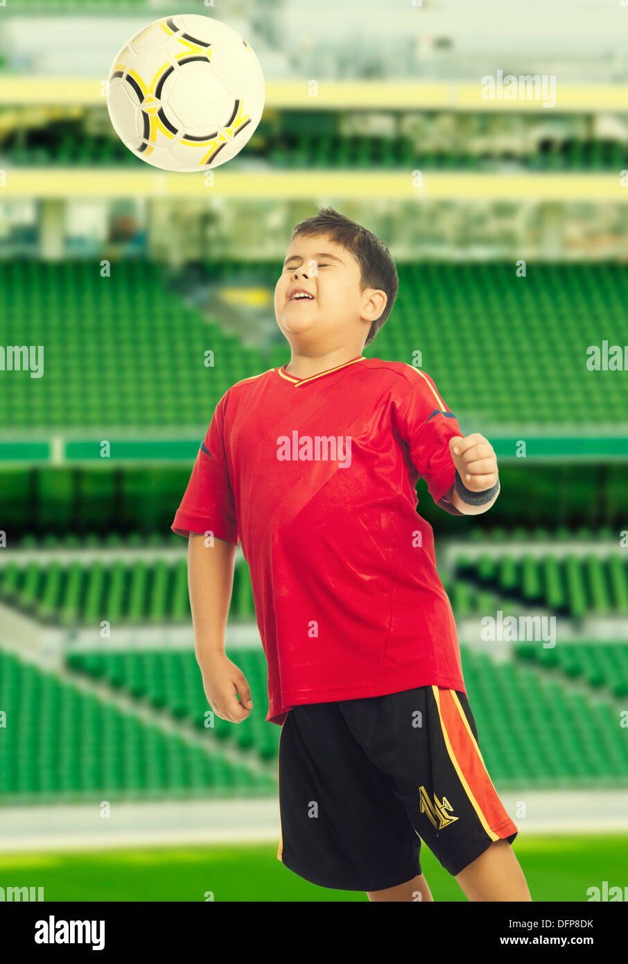 Niño jugando con una pelota de fútbol Foto de stock