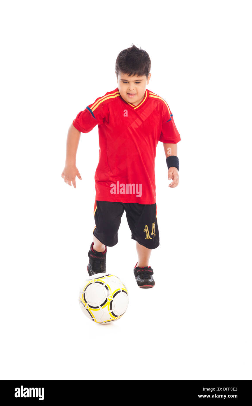 Niño jugando con una pelota de fútbol Foto de stock