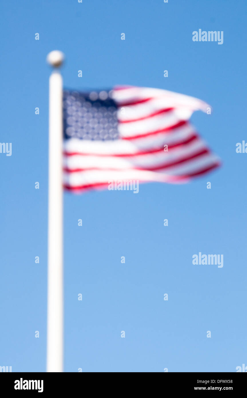 Fuera de foco fotografía de las barras y las estrellas, la bandera nacional de los Estados Unidos de América (EE.UU), contra el cielo azul. Foto de stock
