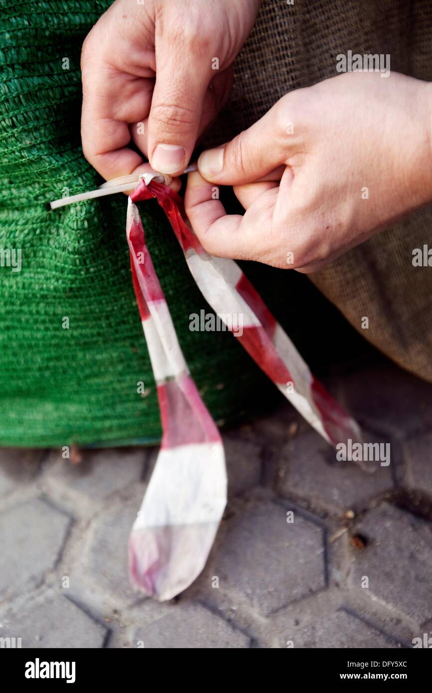Manos de hombre manipulando anu cinta de plastico blanca y roja,manos,manos humanas manipulando una cinta de plástico blanco y rojo Foto de stock