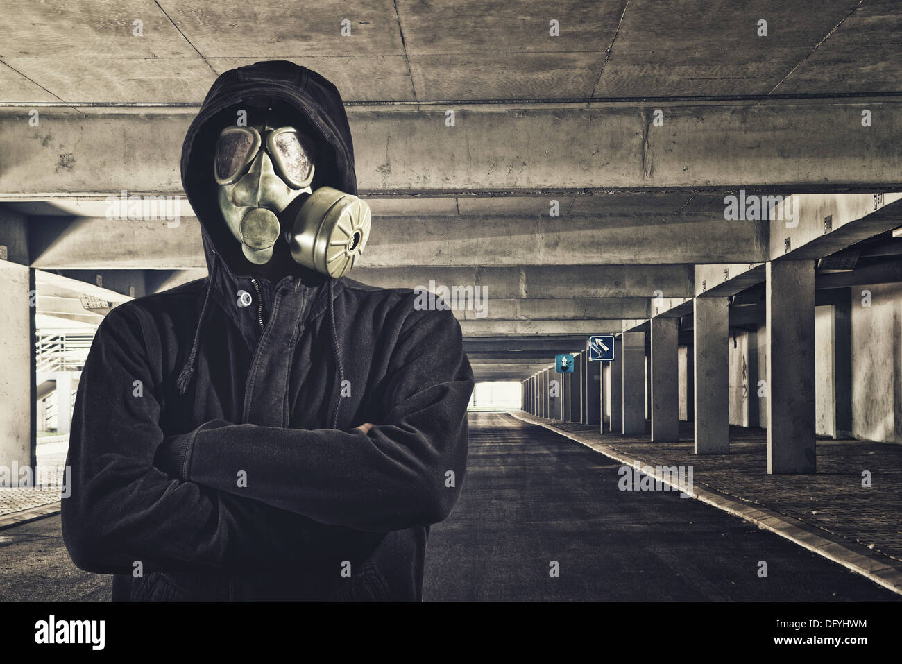 Hombre con máscara de gas en el garaje público. Foto de stock