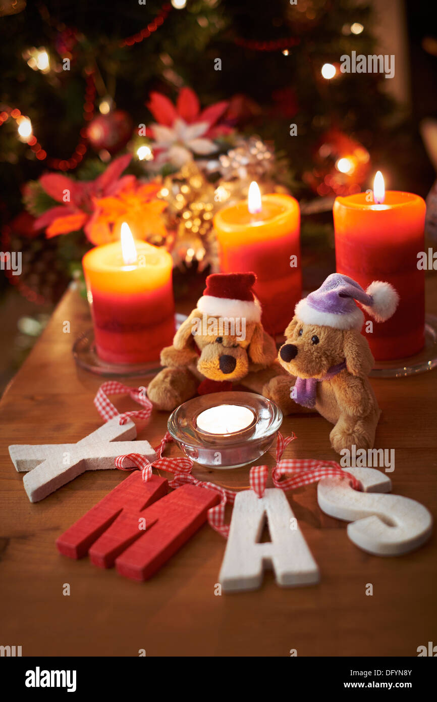 Un árbol de Navidad con escenas de dos osos de peluche con velas encendidas. Foto de stock