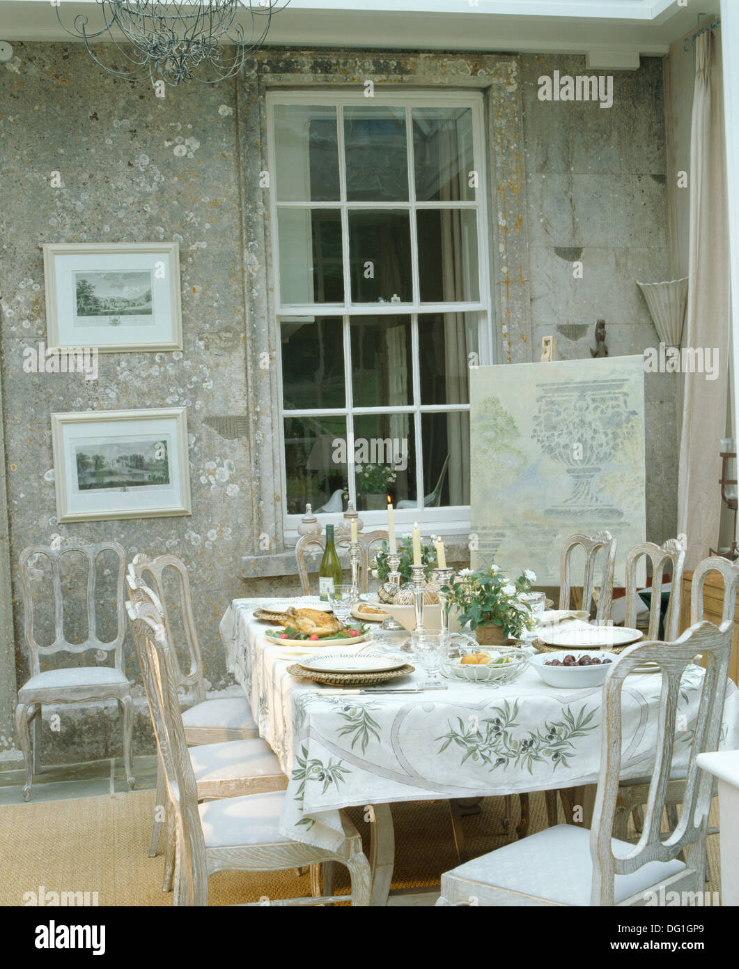 Sillas pintadas en gris en la mesa para comer con telas estampadas de oliva  en comedor con fondo gris y ventana interna Fotografía de stock - Alamy
