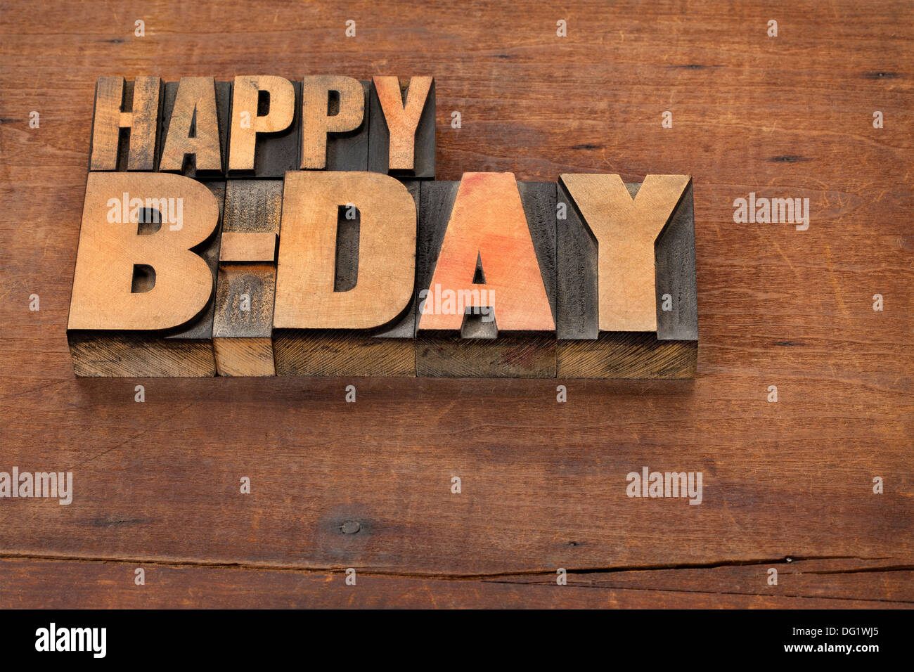 Feliz cumpleaños (b-día) - Texto en tipografía vintage tipo de madera sobre un fondo de madera grunge Foto de stock