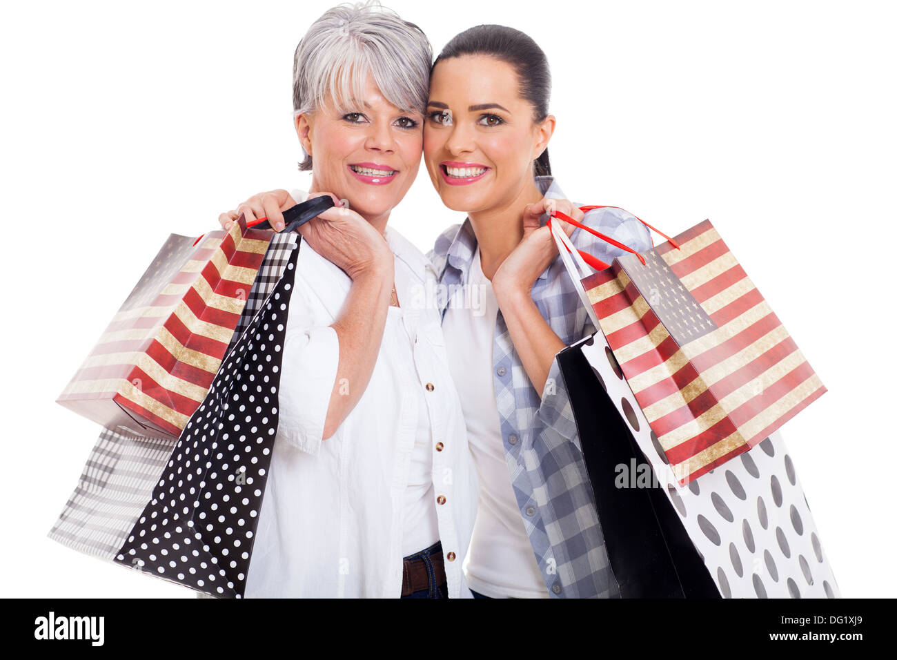 Alegre y madre hija adulta llevando bolsas de compras aislado en blanco Foto de stock