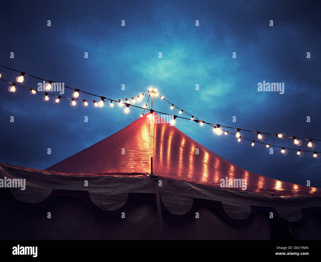 Carpa del circo y cadena de luces por la noche, Vista de ángulo bajo Foto de stock