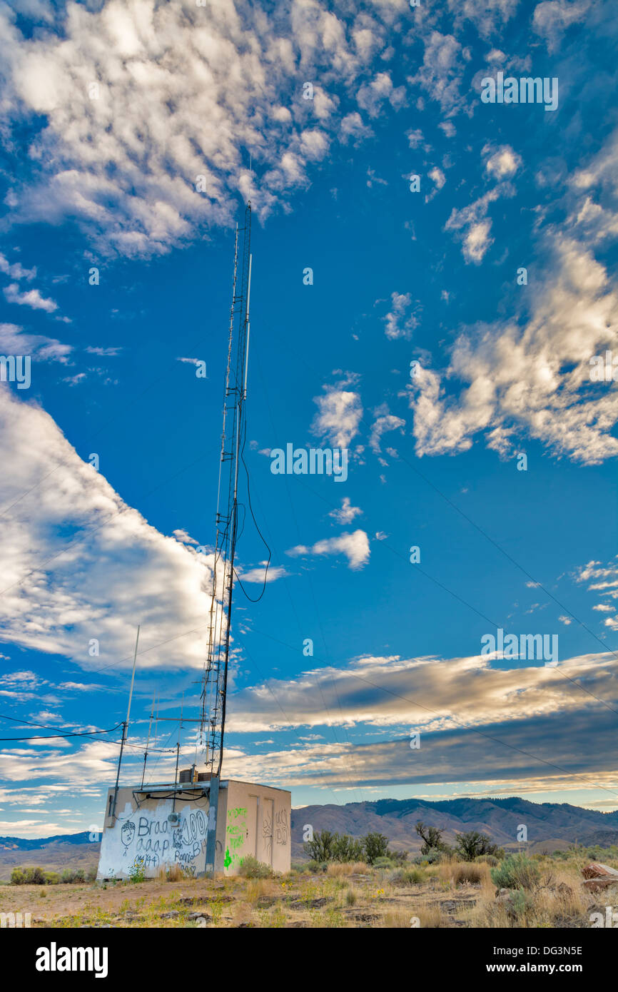 Escrito en el lateral de un edificio con una antena y nubes Foto de stock