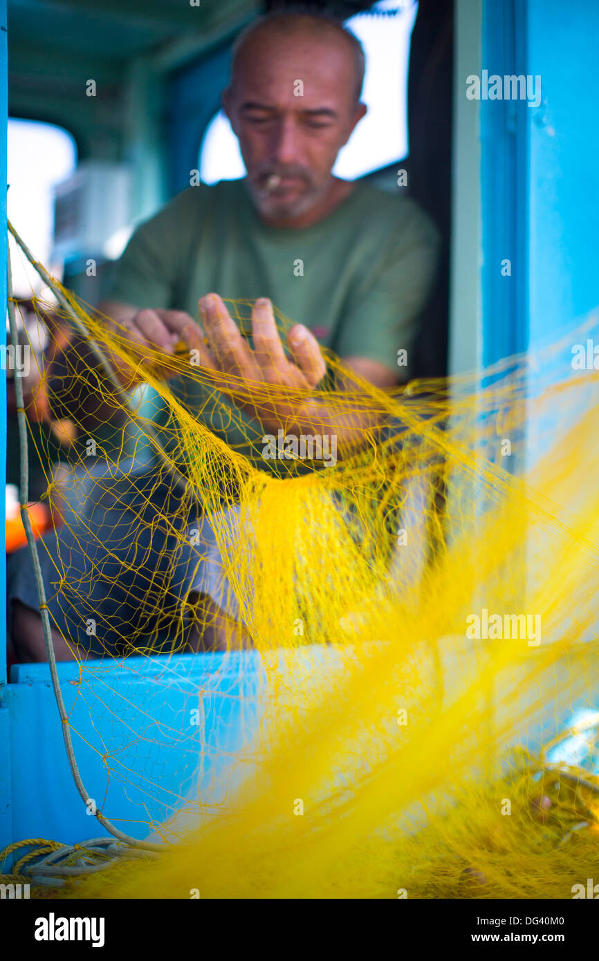 Pescador limpiando sus redes, islas griegas, Mykonos, Grecia, Europa Foto de stock