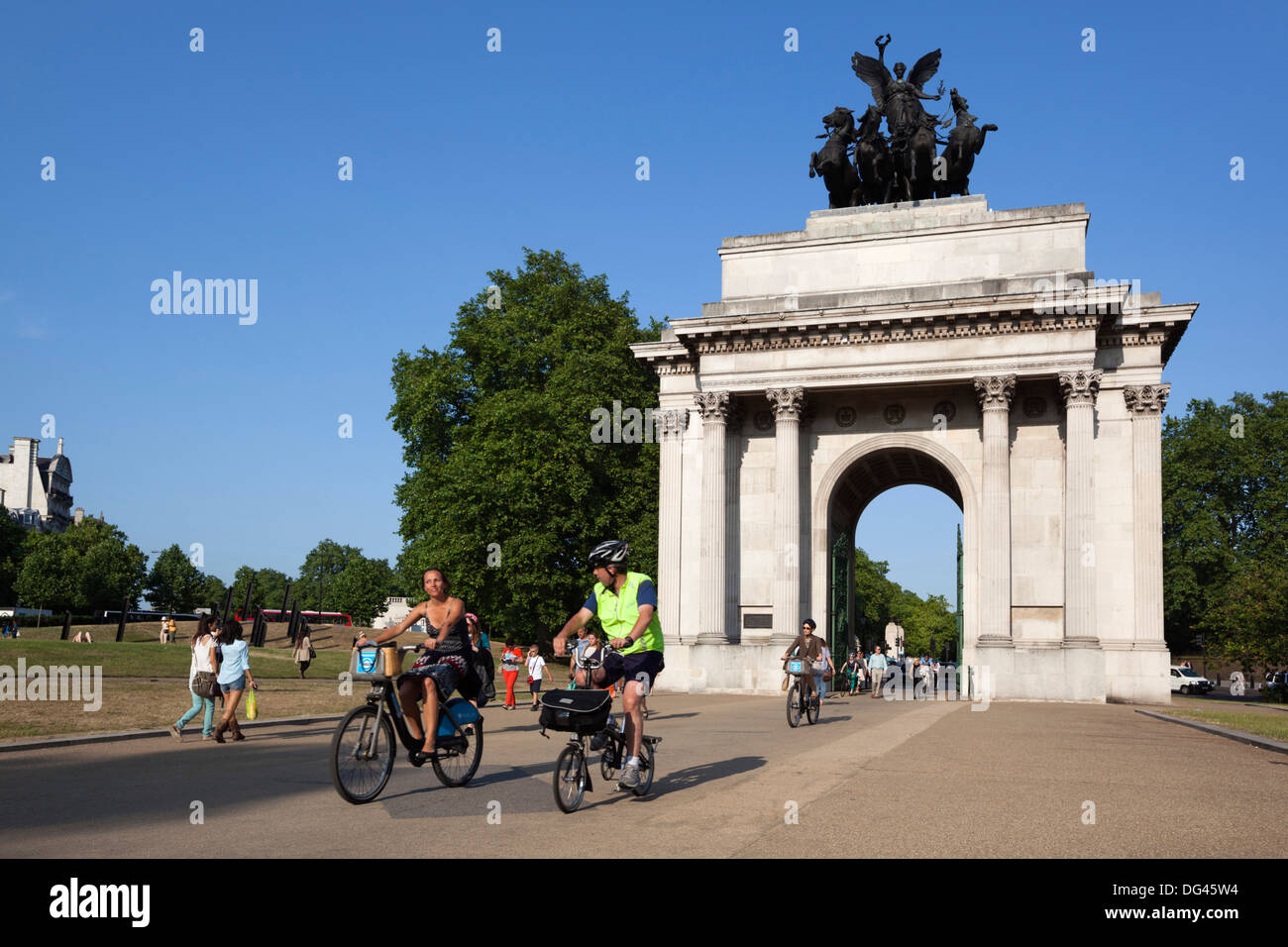 Los ciclistas bajo el arco de Wellington, la Esquina de Hyde Park, Londres, Inglaterra, Reino Unido, Europa Foto de stock