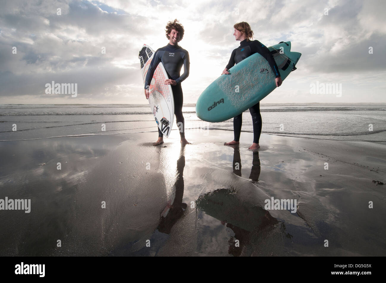 de pie en la playa con tablas de surf, uno tiene una Gopro cámara a tablas surf Fotografía de stock -