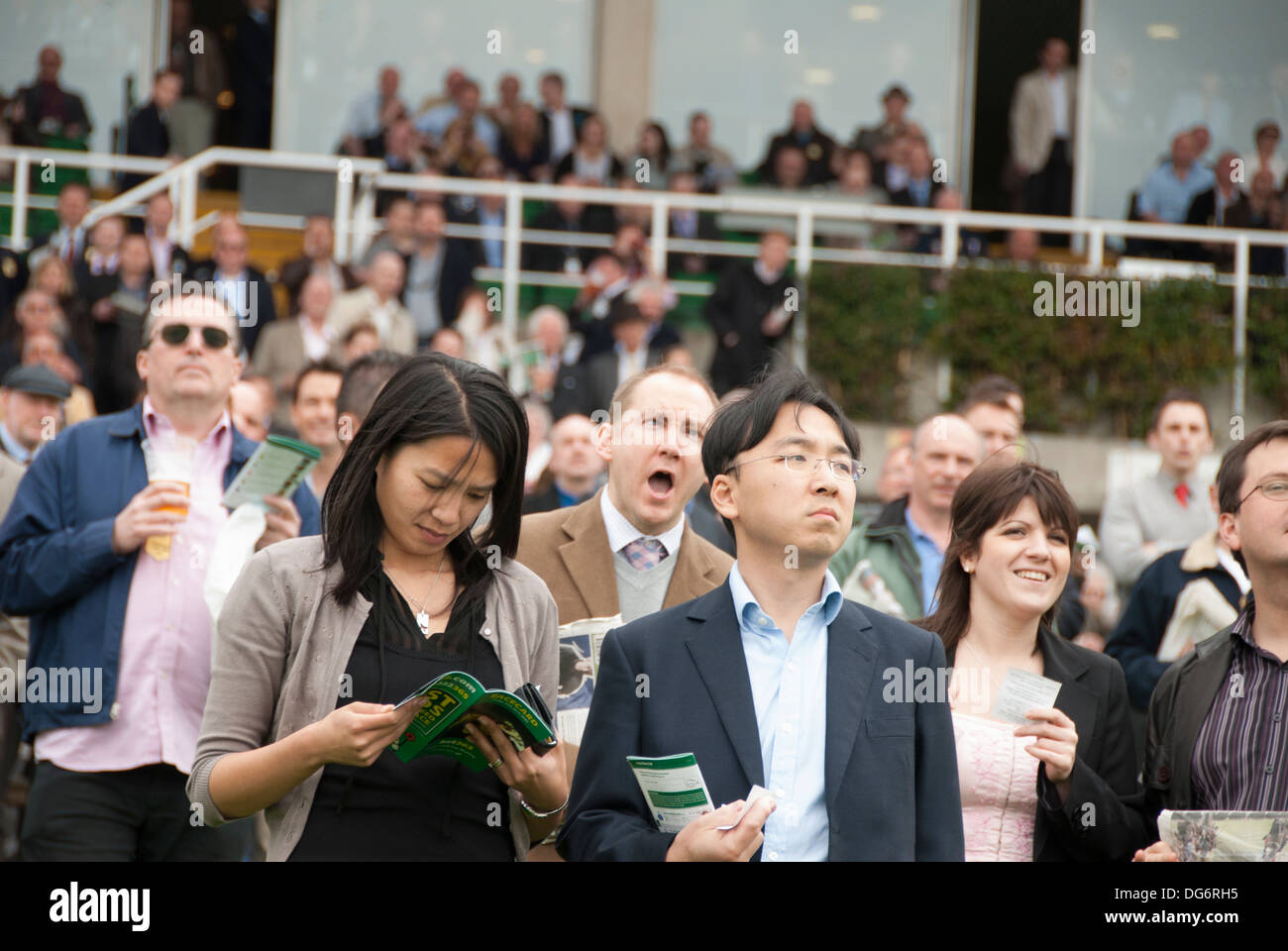 Grupo de personas viendo la carrera de caballos Foto de stock