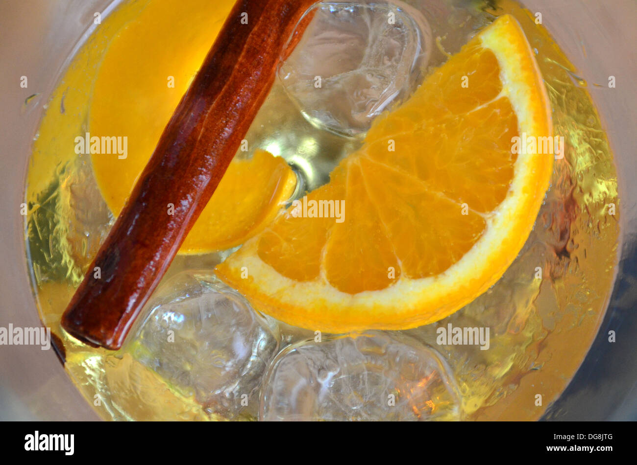 Saffron Gin Tonic con canela, hielo y rodajas de naranja fotografiado desde arriba. Foto de stock
