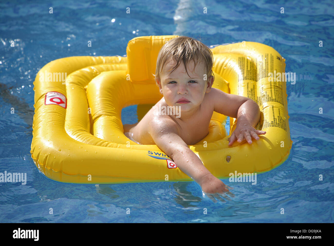 Boy pasando en grande en la piscina, tomando ventaja de las vacaciones de verano. Foto de stock