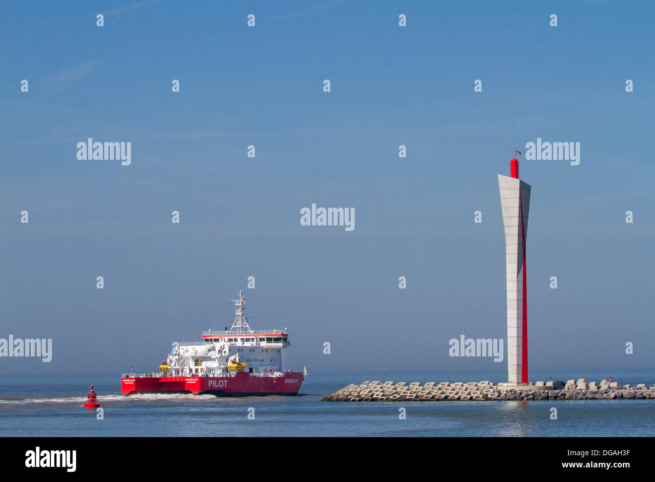 Embarcación saliendo del puerto de Ostende pasado torre de radar en el terraplén longitudinal a lo largo de la costa del Mar del Norte, Bélgica Foto de stock