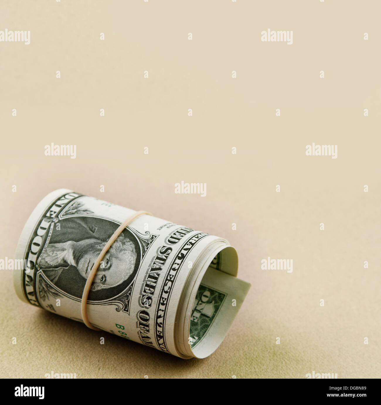 Rollo de billetes de dólar sobre fondo liso. Espacio de copia Foto de stock