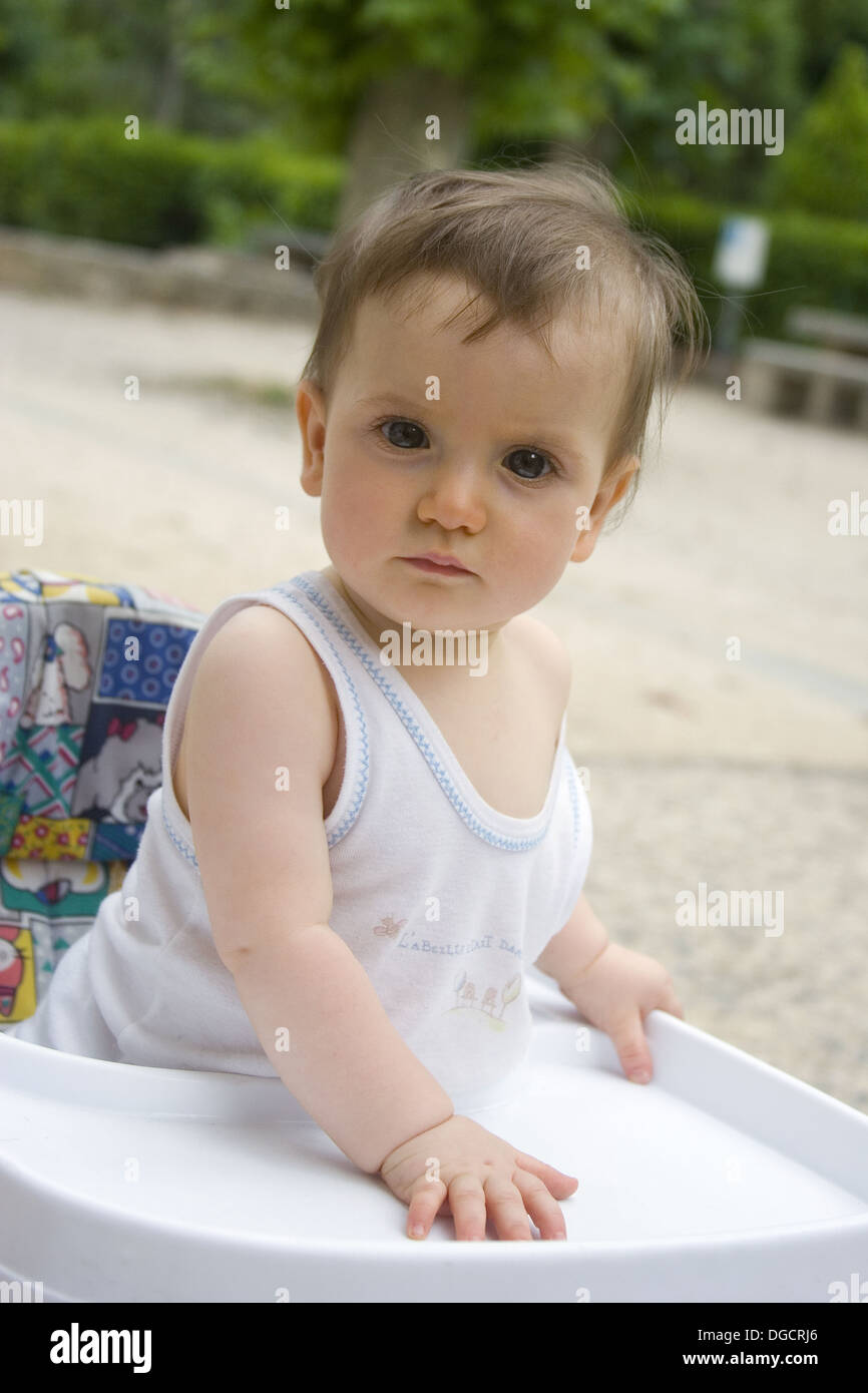 Nina De 14 Meses Fuera De Pie En Un Andador Mirando A La Camara Con Una Expresion Grave Fotografia De Stock Alamy