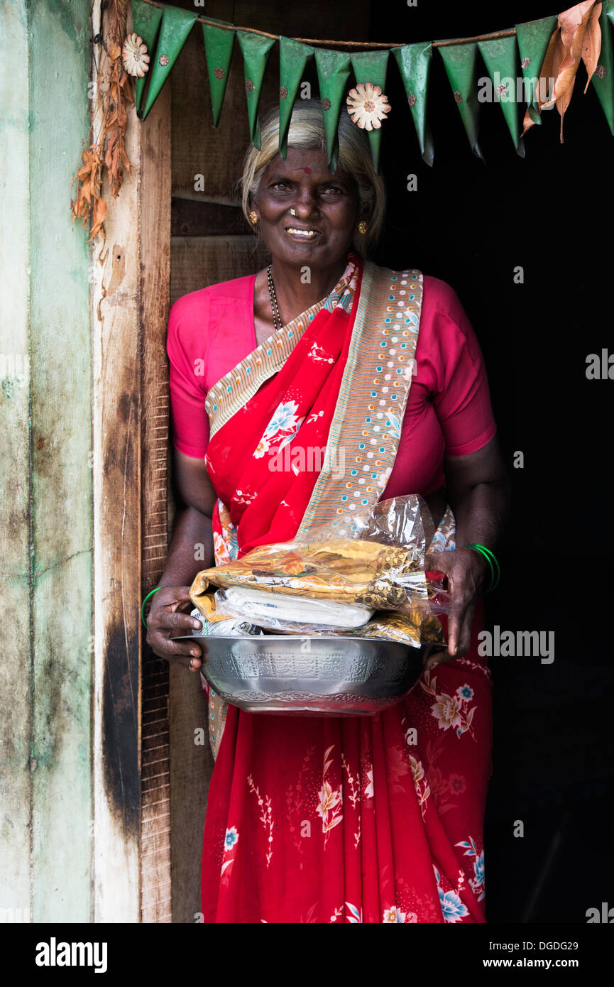 Aldea india mujer con donaciones de alimentos y ropa, dada por la Organización Sri Sathya Sai Baba. En Andhra Pradesh, India Foto de stock