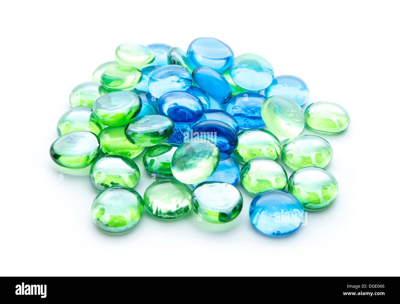 Microesferas de vidrio azul y verde aislado sobre fondo blanco. Foto de stock