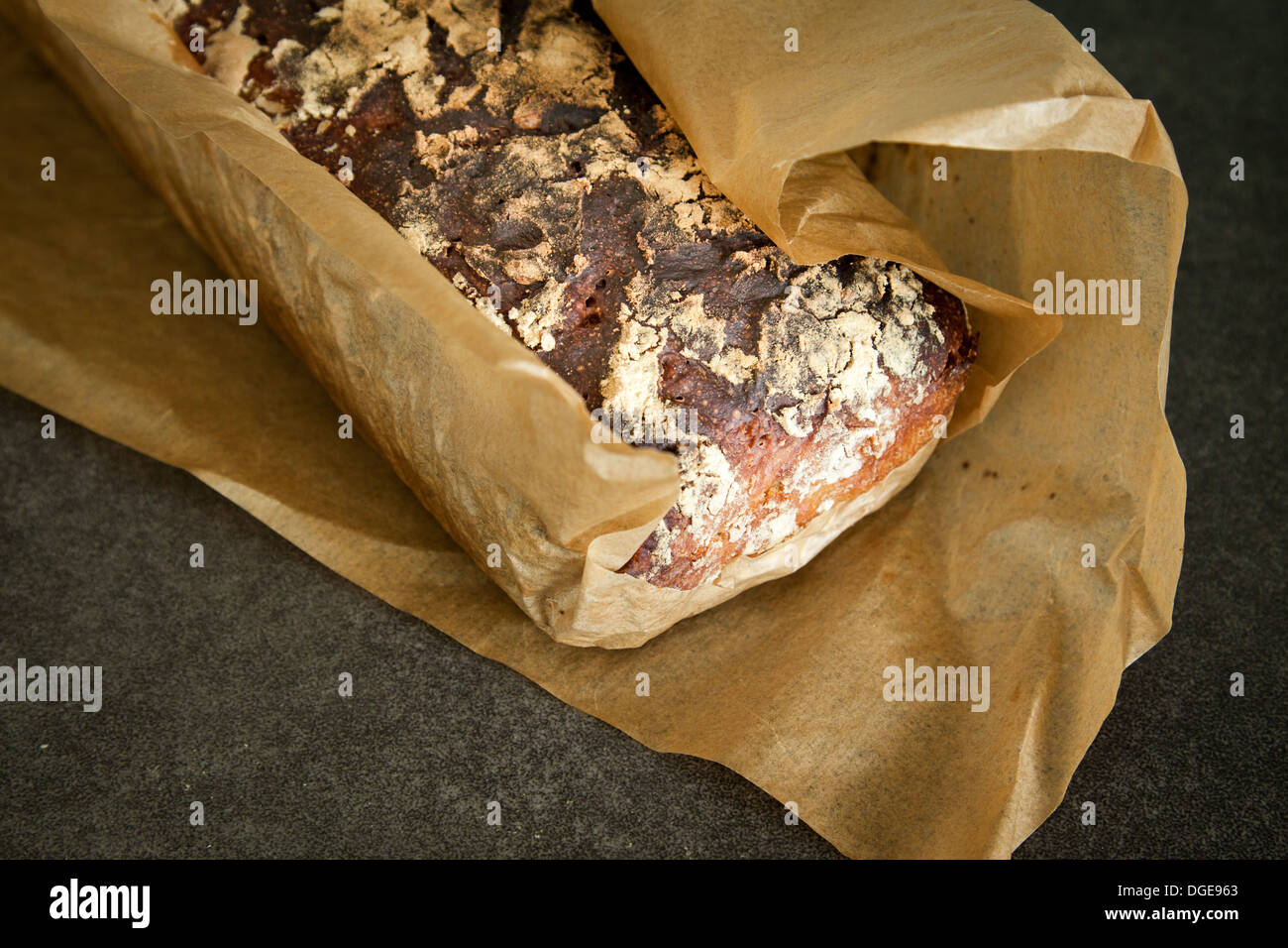 Pan de masa fermentada artesanal recién salido del horno envuelto en papel de cera. Foto de stock