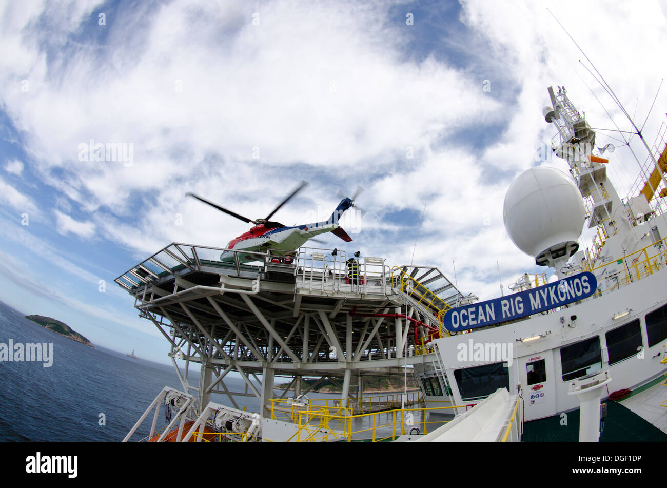 Helicóptero aterrizaba/partiendo desde un buque de perforación petrolera offshore, Ocean RIG Mykonos, fondeado frente de Río de Janeiro, Brasil. Foto de stock