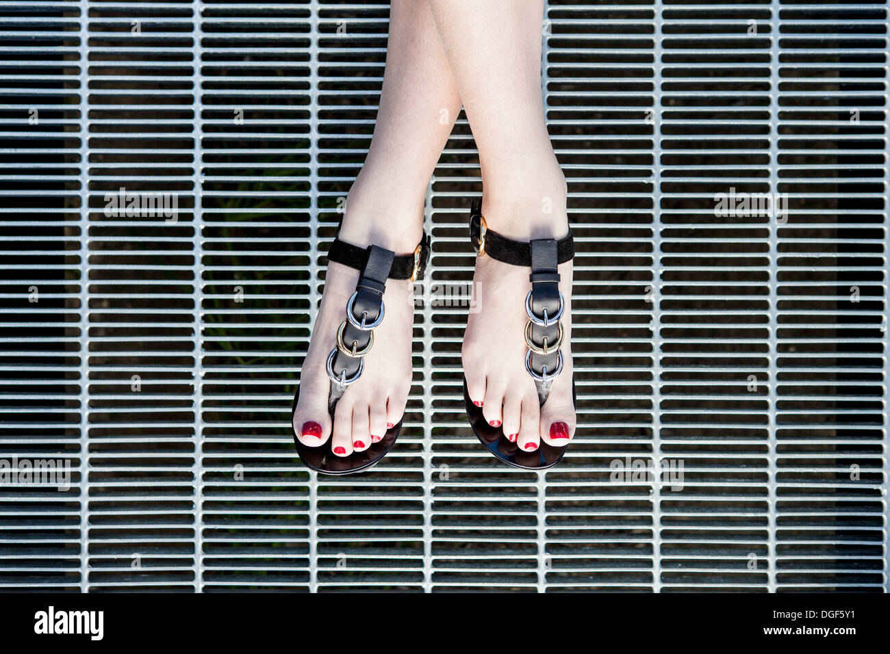 Un modelo femenino llevaba sandalias de cuero negro. Foto de stock