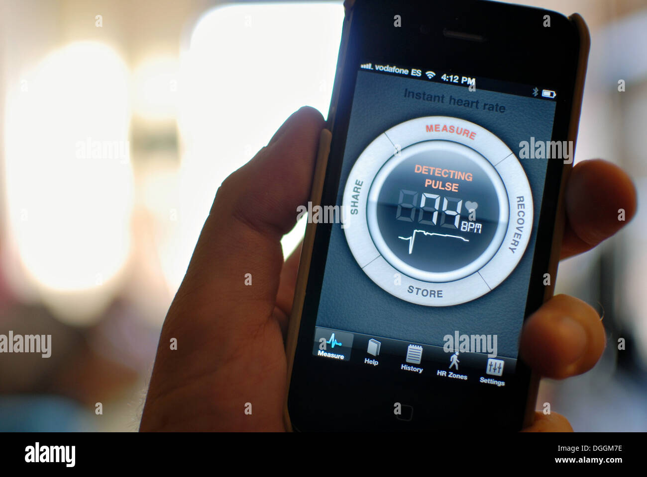 Joven mediante iphone app para medir la frecuencia cardíaca Fotografía de  stock - Alamy
