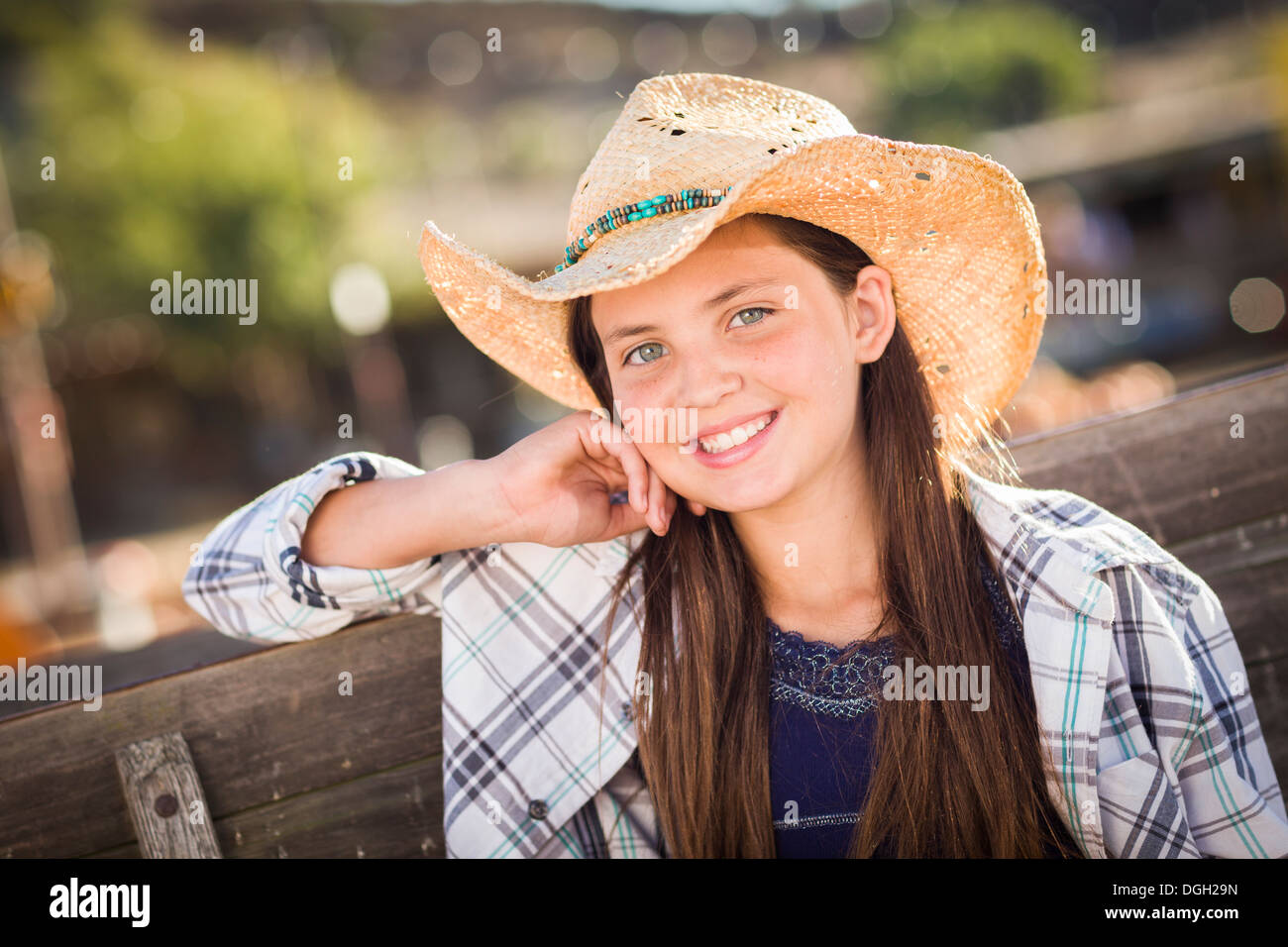 Preadolescentes vestida de cowboy hat retrato en el Pumpkin Patch en un entorno rústico. Foto de stock