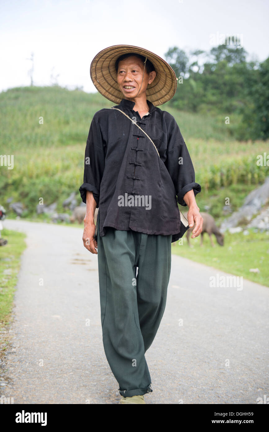 Hombre minoritarios caminar sobre la colina, Bac Ha, Lao Cai, Vietnam Foto de stock