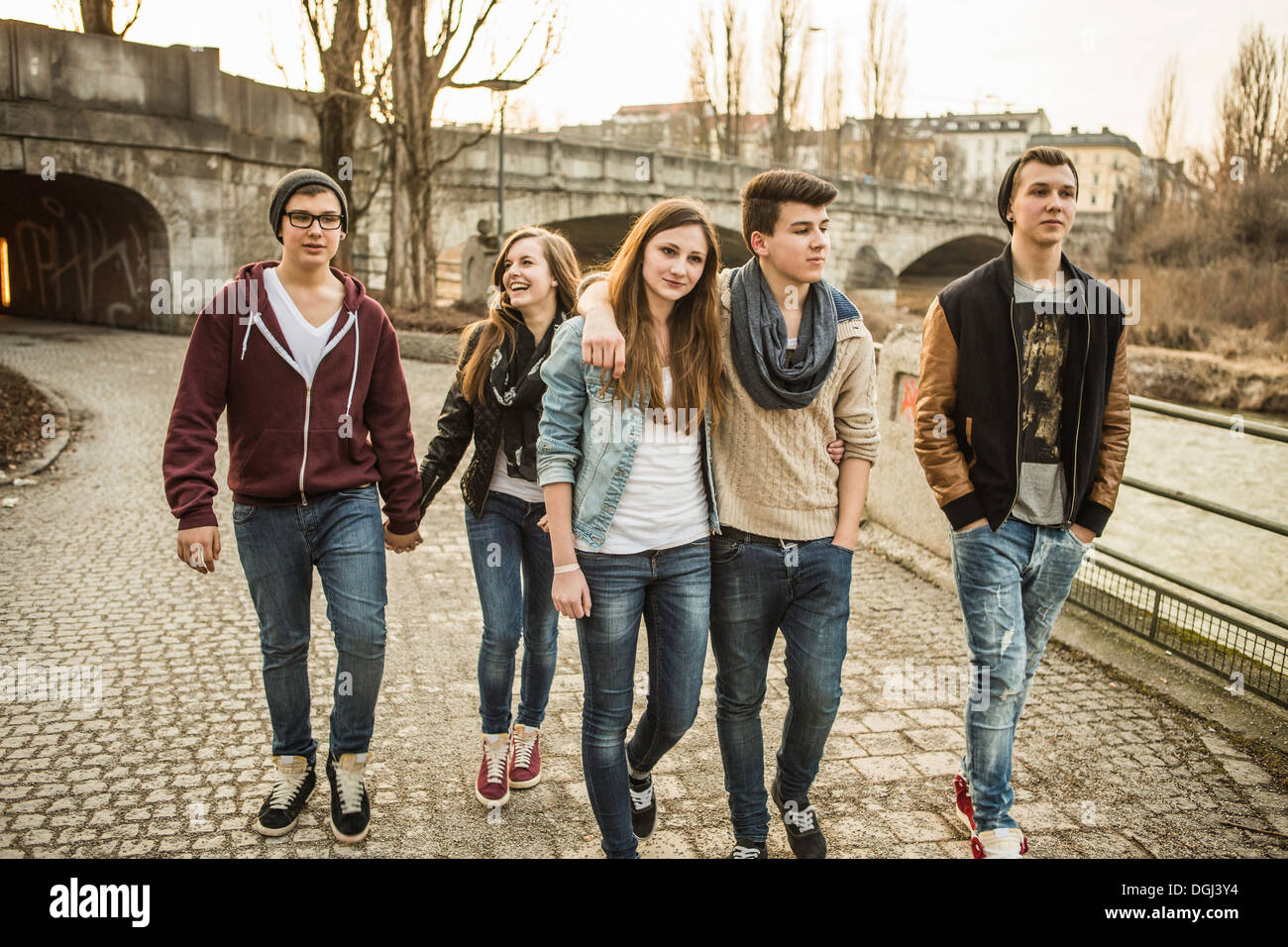 Cinco adolescentes caminando juntos al lado de río Foto de stock