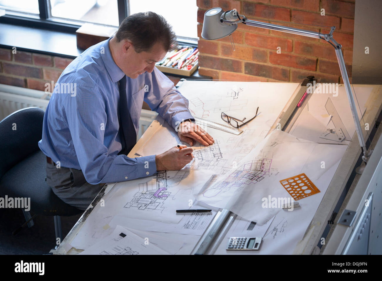 Dibujo de planos de arquitecto al tablero de dibujo Foto de stock