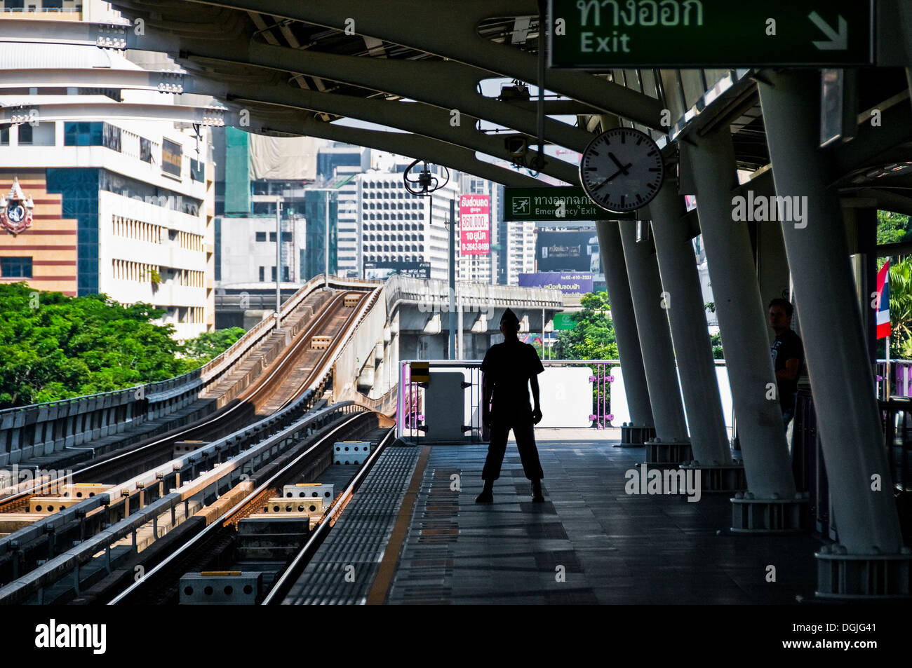 La silueta de un guardia de seguridad en la plataforma de la estación de skytrain Ratchadamri en Bangkok. Foto de stock