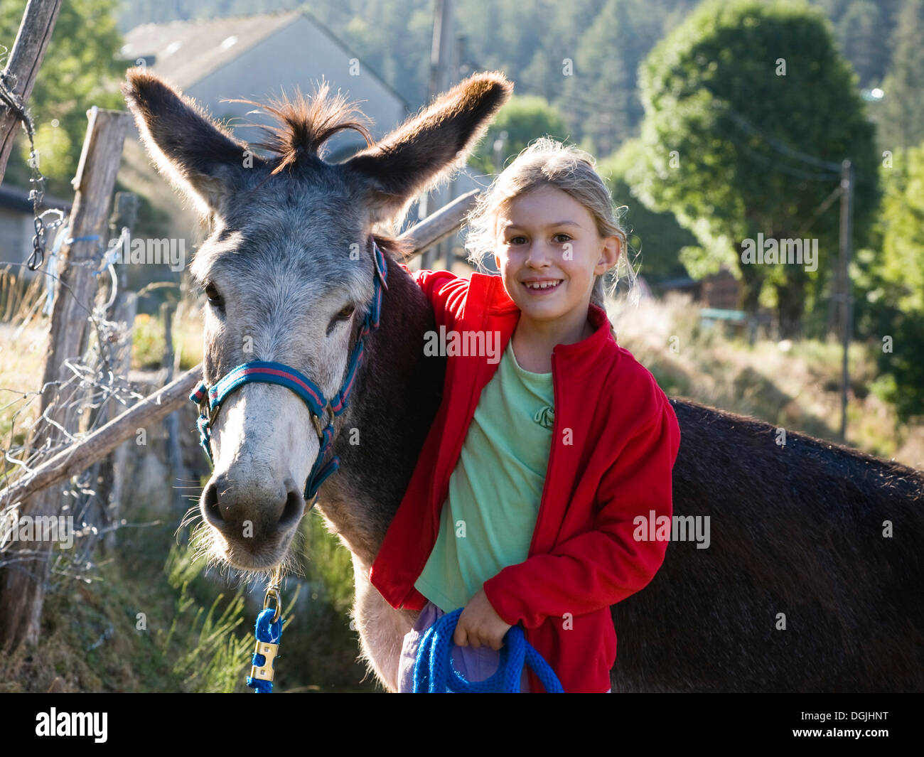 Chica con un burro durante una caminata familiar con un burro en las montañas de Cévennes, Francia, Europa Foto de stock