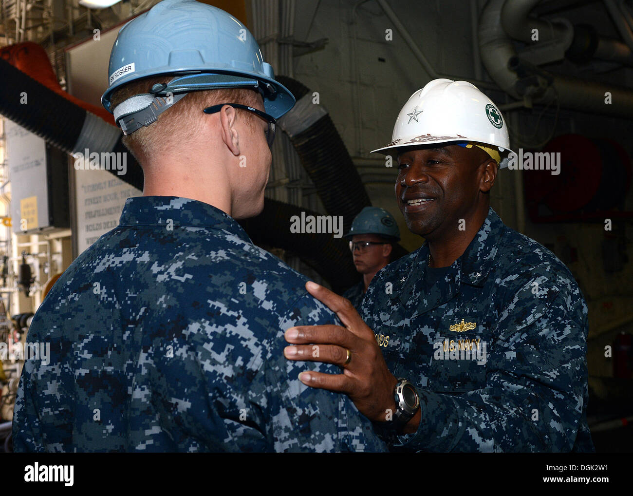 Comandante del Grupo de ataque expedicionario (ESG) 3 Trasero Adm. Frank estanque gracias marinero David Rosser por su servicio a bordo del buque de transporte anfibio dock USS Green Bay (LPD 20). Pond visitó Green Bay por primera vez mientras el buque esté en BAE Systems di San Foto de stock