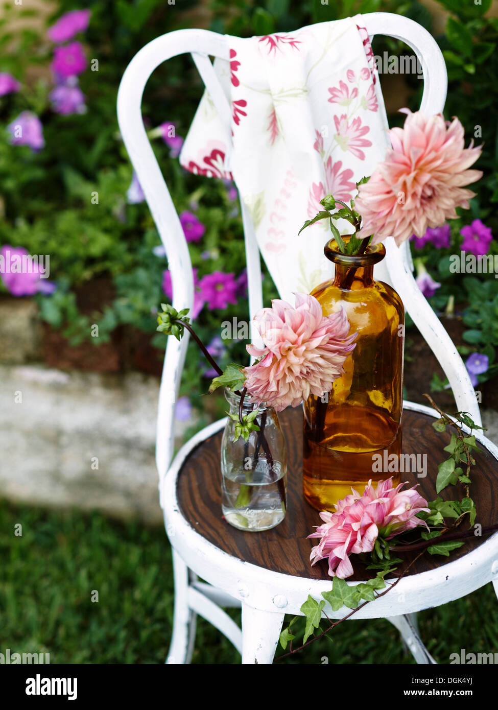 Flores en botellas de vidrio vintage en silla blanca Fotografía de stock -  Alamy