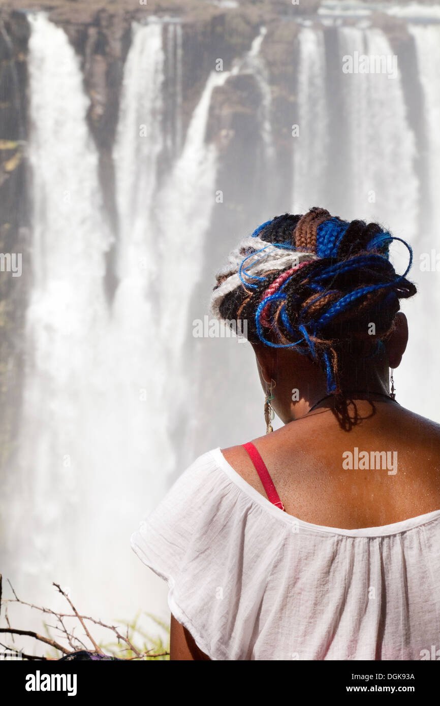 Zimbabwe local mujer sentada mirando la Victoria Falls, Zimbabwe, África Foto de stock
