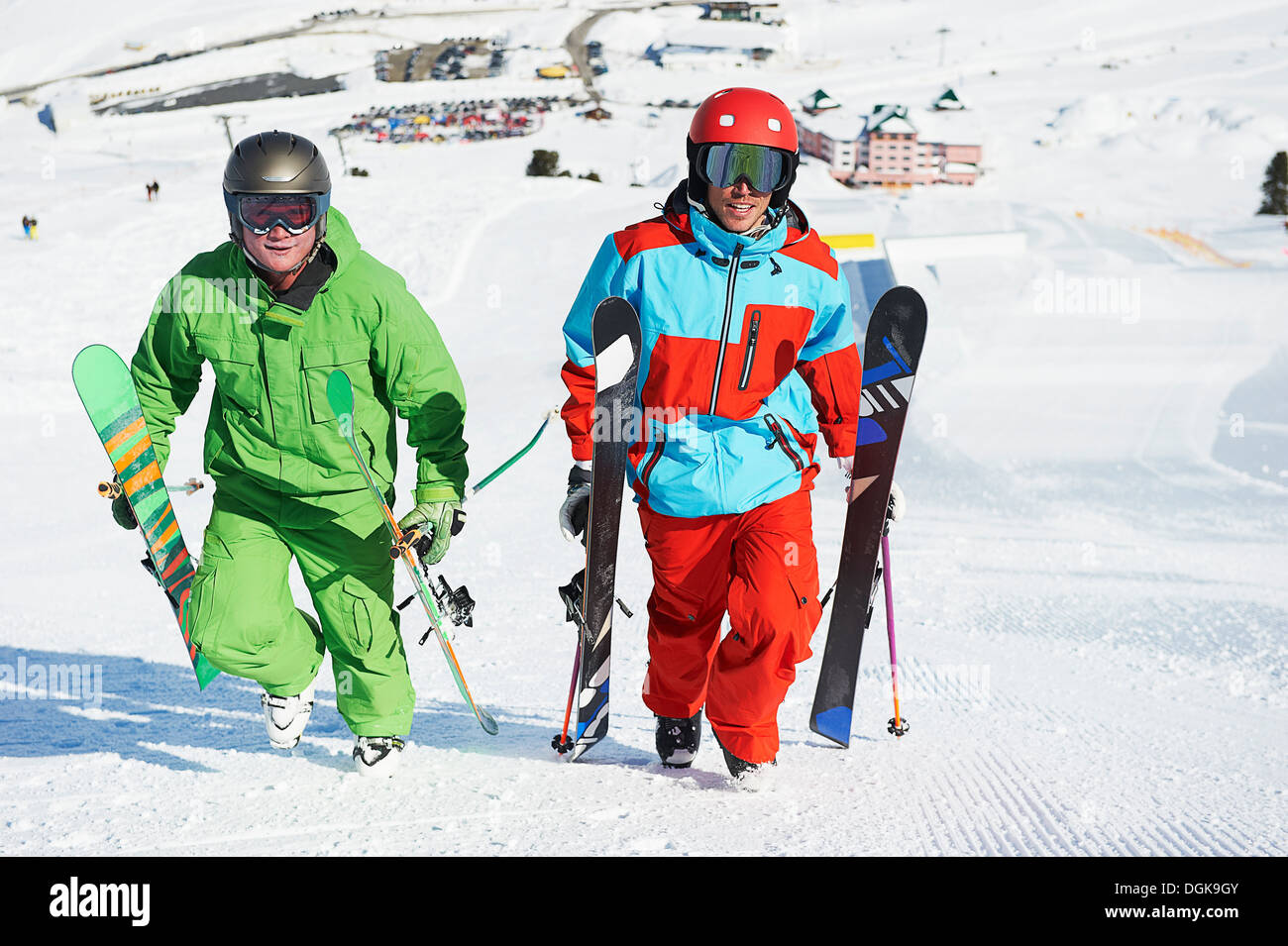 Los esquiadores transportando equipos cuesta arriba Foto de stock