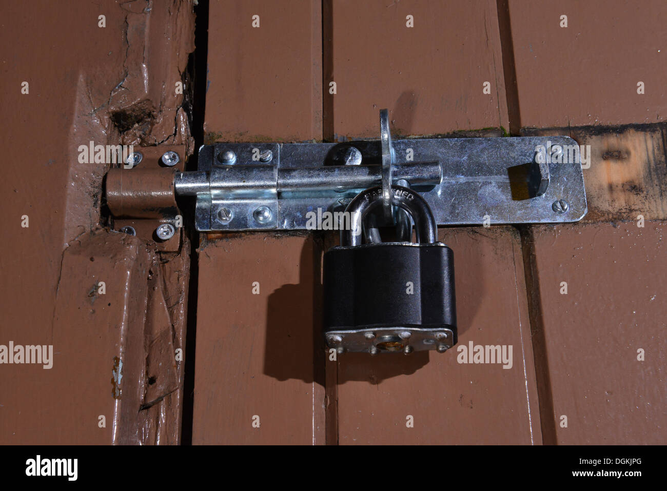 Negro candado moderno asegurar una puerta de madera pintado Fotografía de  stock - Alamy