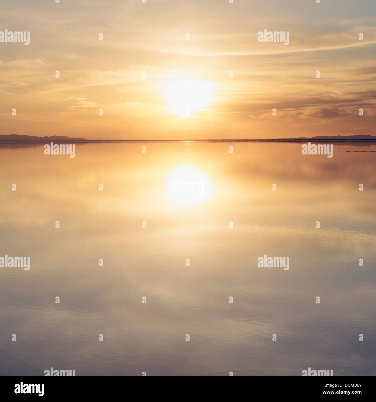 Aguas poco profundas sobre la superficie en las salinas de Bonneville, en la puesta de sol. Foto de stock